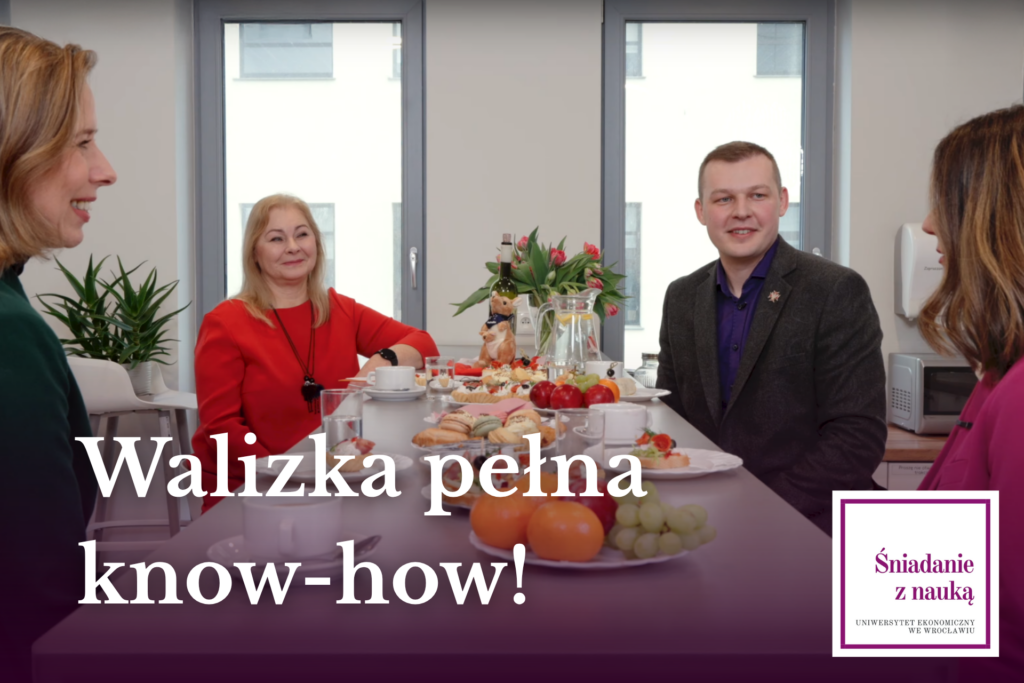 Staże naukowe – czy warto. Przy śniadaniowym stole siedzą cztery osoby i rozmawiają. Napis: Walizka pełna know-how! W prawym dolnym rogu logo cyklu Śniadanie z Nauką