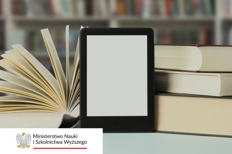 Na pierwszym planie czytnik e-booków oparty o książki/doktoraty. W tle półka z książkami