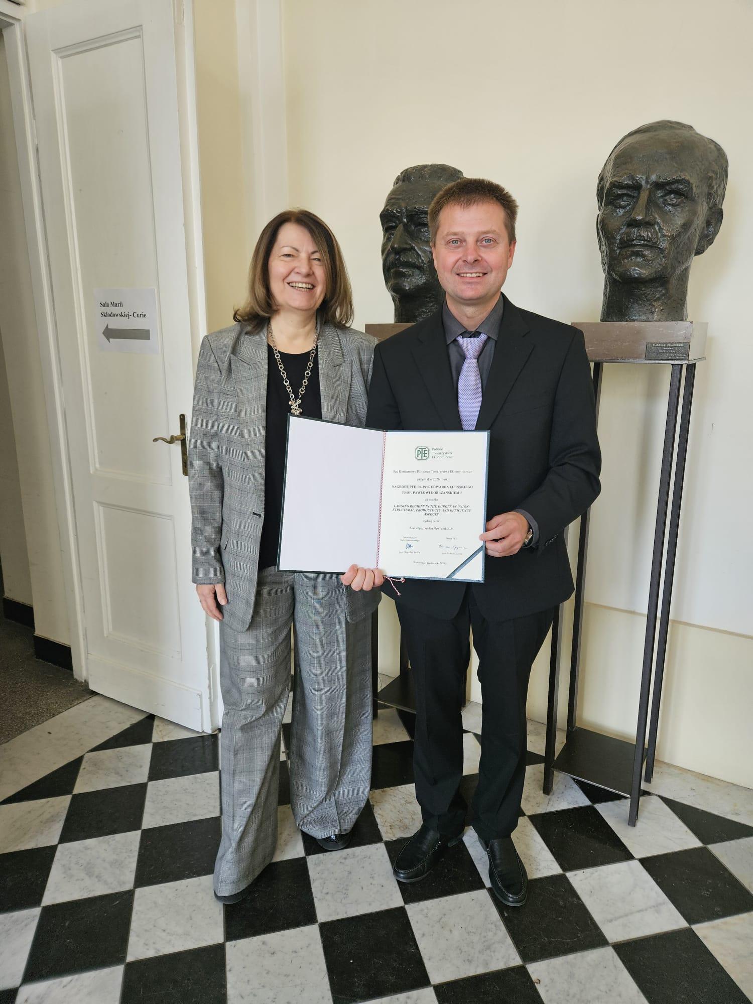 Na zdjęciu dr hab. Paweł Dobrzański trzymający nagrodę PTE oraz Profesor Bogusława Drelich-Skulska
